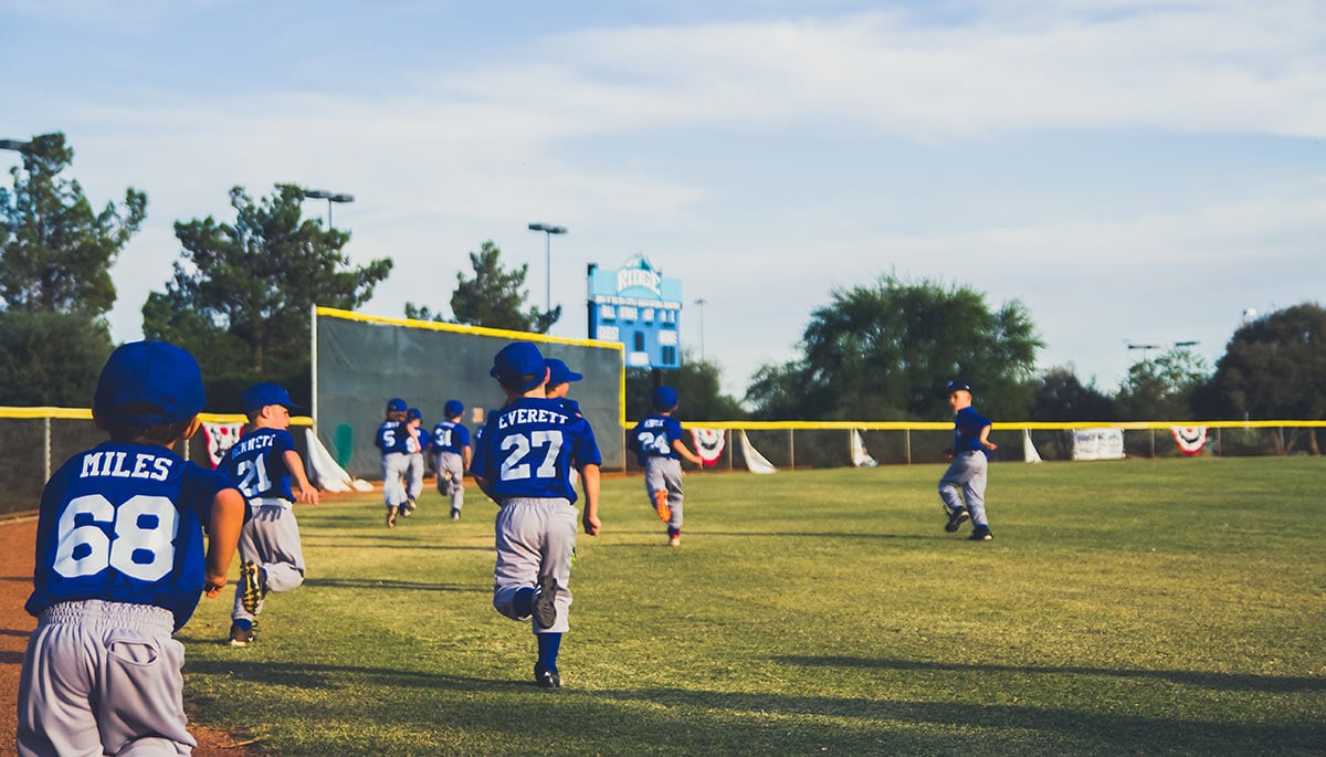 Children playing sports on a baseball field 