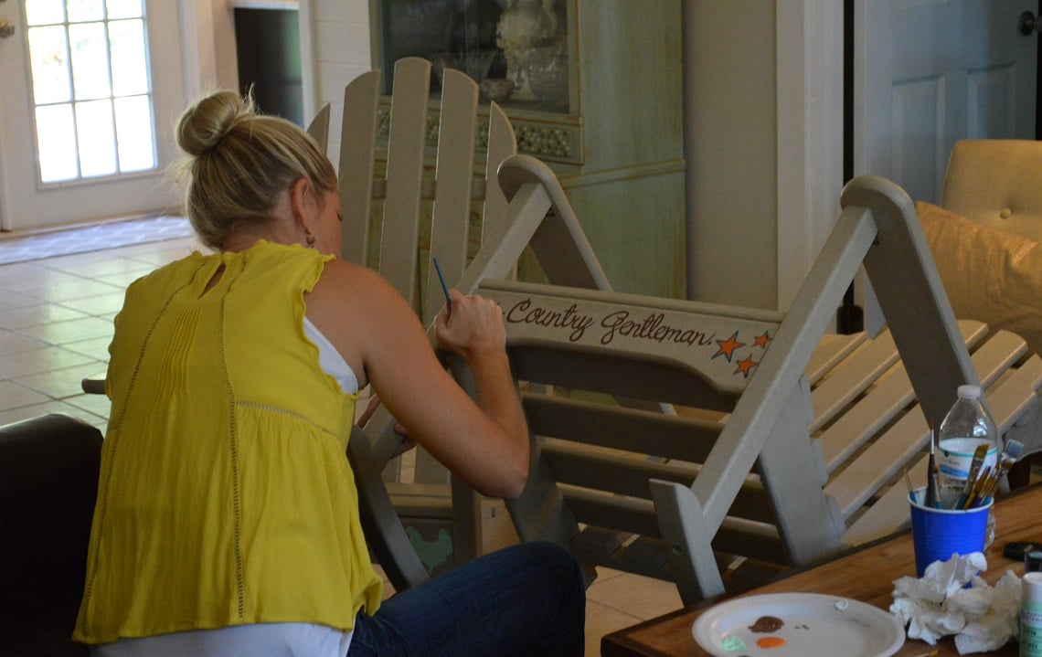 Artist paints rocking chairs for Sunbelt Ag Expo